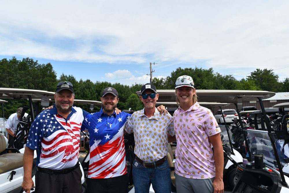 Group of four golfers posing for photo