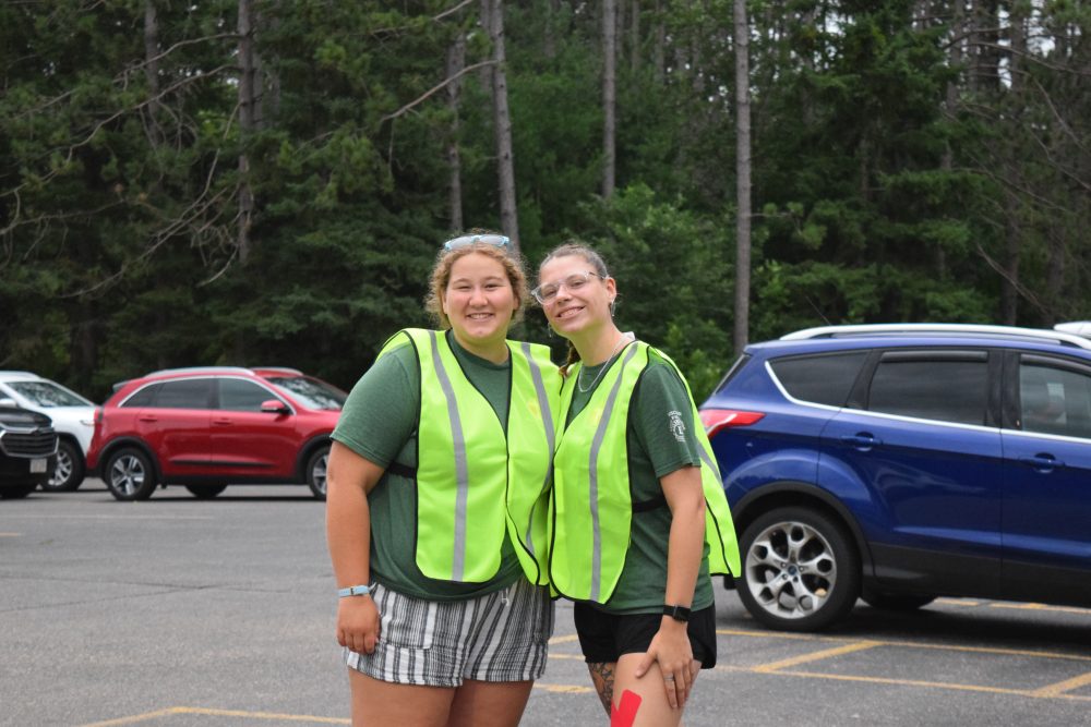 Two staff in safety vests smiling