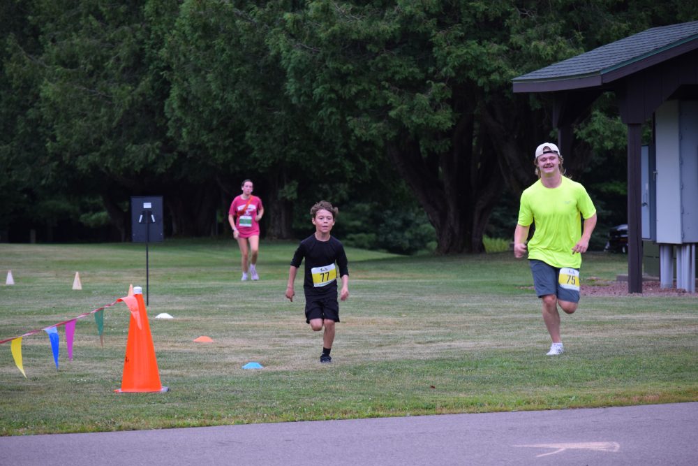 Three people running towards the finish line